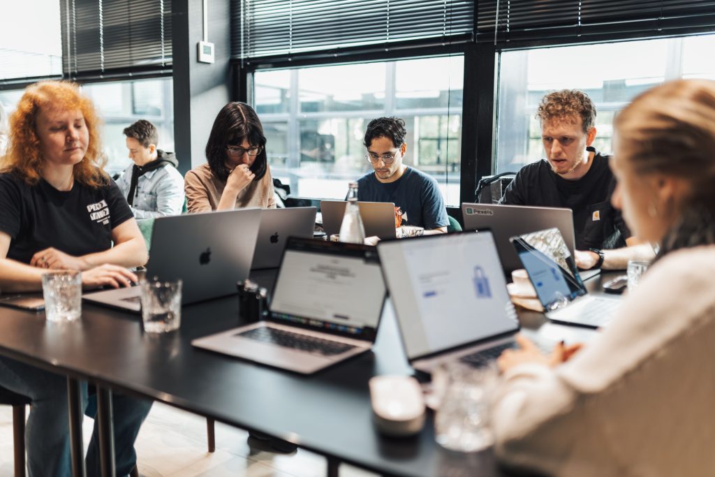 Účastníci firemného vzdelávania pracujú počas workshopu na notebookoch